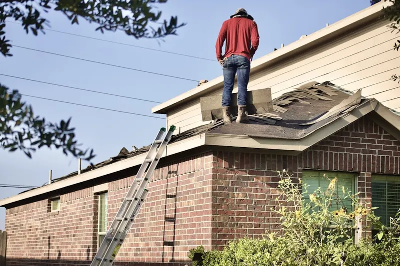 Professional roofer working on a residential roof in West Athens